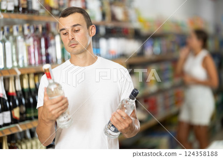 Young man choosing vodka in store 124358188