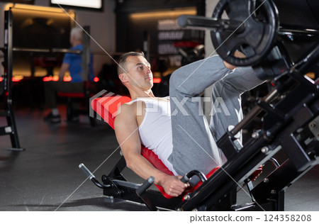 Athlete pulls his legs to his chest on special simulator 124358208