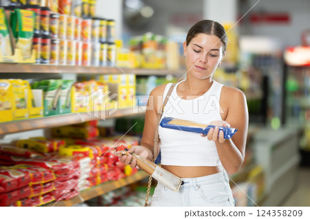 Girl buyer chooses between variation of noodles 124358209