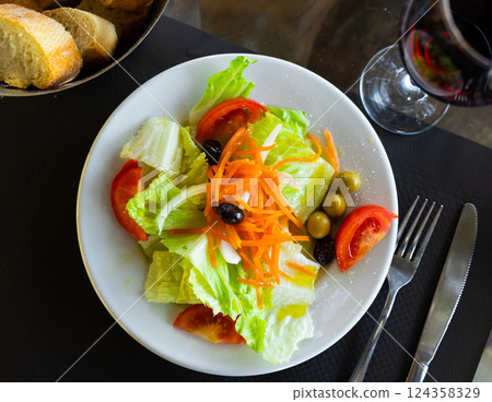 Mixed salad of carrot, lettuce, tomatoes and olives close up Mixed salad of carrot, lettuce, tomatoes and olives close up 124358329