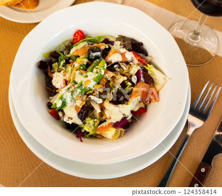 Fresh green lettuce salad with smoked salmon. 124358414