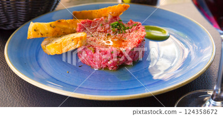 Image of delicious veal steak tartar served at plate with fried bread Image of delicious veal steak tartar served at plate with fried bread 124358672