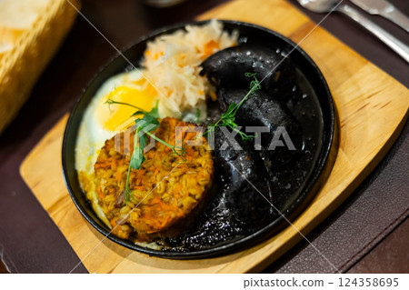 Blood sausage served with barley on plate 124358695
