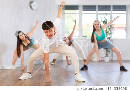 Group of young women and young guy dancing hip hop Group of young women and young guy dancing hip hop 124358698