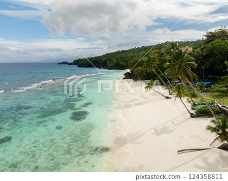 Transparent clear ocean waves over the white sandy beaches in Carabao Island, Romblon, Philippines. 124358811