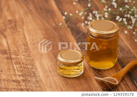 Honey jar com honey on wood grain 124359178