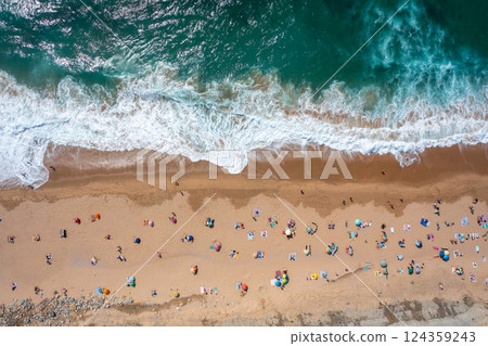 Tourists and parasols on sandy beach during summer Tourists and parasols on sandy beach during summer 124359243