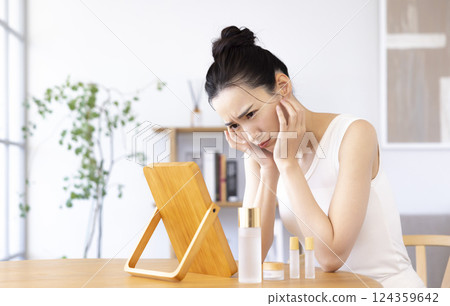 生活方式:一位女士一邊照鏡子一邊進行皮膚護理 生活方式:一位女士一邊照鏡子一邊進行皮膚護理 124359642