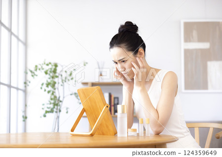 生活方式:一位女士一邊照鏡子一邊進行皮膚護理 生活方式:一位女士一邊照鏡子一邊進行皮膚護理 124359649