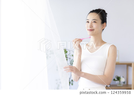 Lifestyle: A woman brushing her teeth in the morning 124359938