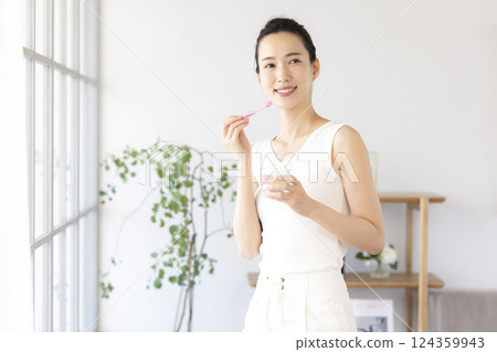 Lifestyle: A woman brushing her teeth in the morning 124359943
