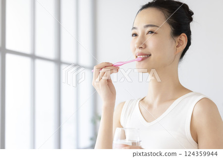 Lifestyle: A woman brushing her teeth in the morning 124359944