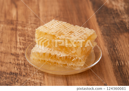 Comb honey on wood grain Comb honey on wood grain 124360081