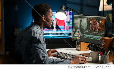 African american videographer works on editing film footage at home, doing freelance contract for post production scenes. Editor correcting white balance and color grading, pc software. Camera B. 124360368