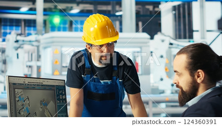 Photovoltaics factory manager delegating tasks to employee, improving solar panels efficiency. Team leader sends worker to make adjustments after researching more sustainable solar solutions, camera B Photovoltaics factory manager delegating tasks to employee, improving solar panels efficiency. Team leader sends worker to make adjustments after researching more sustainable solar solutions, camera B 124360391