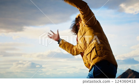 Hiker battling strong winds and cold weather tumbles over a cliff on the mountain top, dangerous risky place for trekking. Unprepared adventure seeker being foolish and tripping. Camera B. Hiker battling strong winds and cold weather tumbles over a cliff on the mountain top, dangerous risky place for trekking. Unprepared adventure seeker being foolish and tripping. Camera B. 124360418