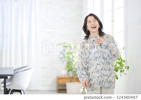 A smiling middle-aged woman wearing a floral blouse 124360487