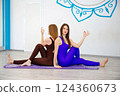 Two women practicing yoga together in a studio 124360673