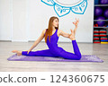Woman practicing advanced yoga pose on a purple mat  124360675