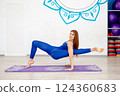 Flexible woman performing an advanced yoga arm balance pose  124360683