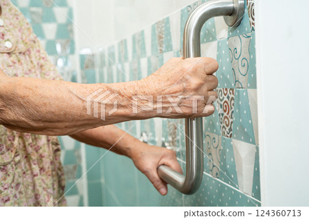Asian elderly woman patient use handrail safety in toilet support rail in bathroom. Asian elderly woman patient use handrail safety in toilet support rail in bathroom. 124360713
