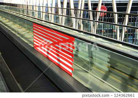 adhoc repair for Cracked or broken glass wall of public Automatic escalator walkway. Red tape Repair to conceal broken glass wall corridor. adhoc repair for Cracked or broken glass wall of public Automatic escalator walkway. Red tape Repair to conceal broken glass wall corridor. 124362661