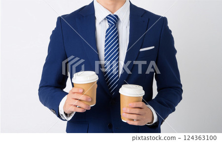 A man in a suit holding a cup of coffee 124363100