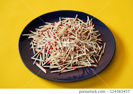 Matches in dark blue plate over yellow background 124363457