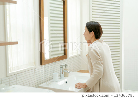 中年婦女在浴室裡看著鏡子 中年婦女在浴室裡看著鏡子 124363793
