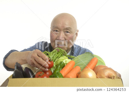 A smiling old man packing rice and vegetables into cardboard boxes A smiling old man packing rice and vegetables into cardboard boxes 124364253