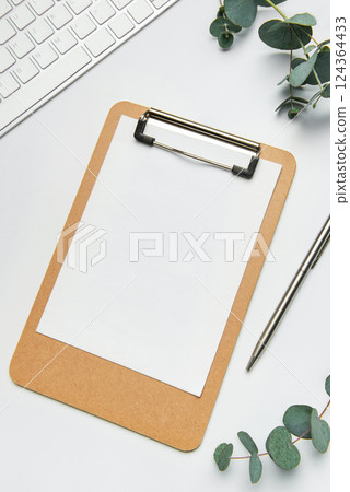 Clipboard with blank paper, pen, keyboard and eucalyptus branches Clipboard with blank paper, pen, keyboard and eucalyptus branches 124364433