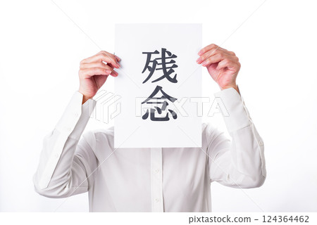 A person holding up a piece of paper with the word "regret" written on it A person holding up a piece of paper with the word "regret" written on it 124364462