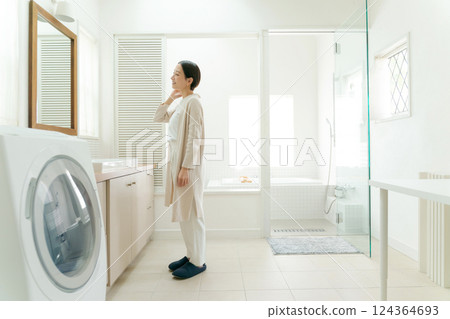 A housewife looking in the mirror in the bathroom A housewife looking in the mirror in the bathroom 124364693