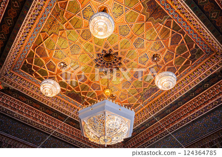 beautiful carved wooden painted ceiling with an ancient chandelier in Museum of Art of Uzbekistan with traditional Uzbek ornaments and decorative oriental patterns in Uzbekistan 124364785