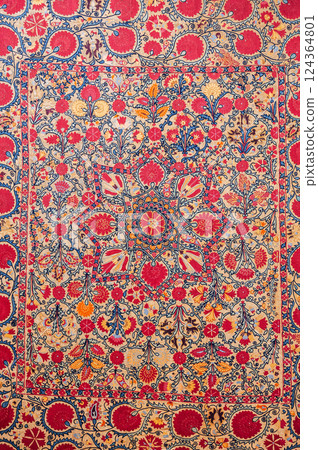 traditional Uzbek asian pattern on ancient handmade carpet in Uzbekistan. Oriental background with beautiful ornaments traditional Uzbek asian pattern on ancient handmade carpet in Uzbekistan. Oriental background with beautiful ornaments 124364801