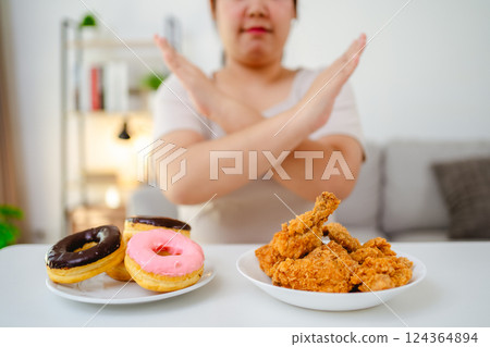 A woman refuses to eat fast food, fried chicken and donuts on her plate to lose weight A woman refuses to eat fast food, fried chicken and donuts on her plate to lose weight 124364894
