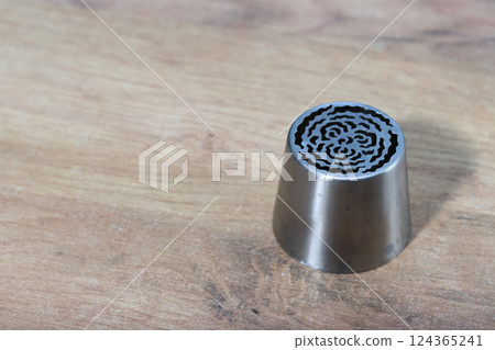 Tip for making marshmallow tulips. Pastry tip made of metal. Close-up view. Oblique Angle. 124365241