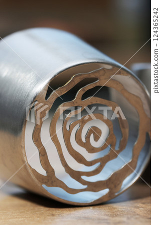 Tip for making marshmallow tulips. Pastry tip made of metal. Close-up view. Lying on its side. Tip for making marshmallow tulips. Pastry tip made of metal. Close-up view. Lying on its side. 124365242