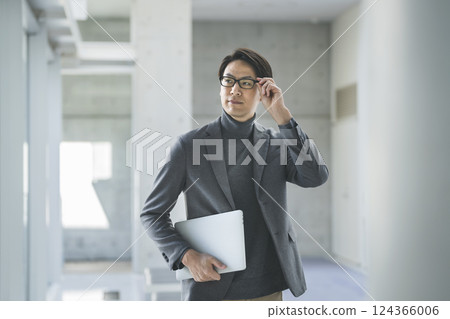 一名 40 多歲的男子拿著一台筆記型電腦 一名 40 多歲的男子拿著一台筆記型電腦 124366006