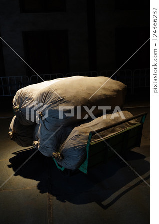 A suspicious burlap sack in the dark 124366232