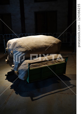 A suspicious burlap sack in the dark 124366235