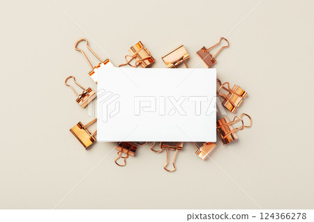 Business card on copper binder paper clips on beige background, mockup Business card on copper binder paper clips on beige background, mockup 124366278