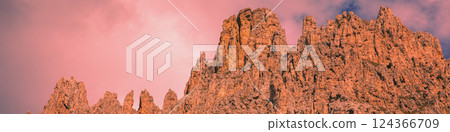 Mountain landscape in the evening. The Dolomites Alps against the sunset sky. Sella Pass, Grohmannspitze, Selva di Val Gardena, Bolzano, Italy. Horizontal banner 124366709