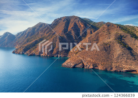 Rocky seashore on a sunny day. Seascape in daylight. Cabo de Gata-Nijar reserve. Almeria Andalusia Spain Rocky seashore on a sunny day. Seascape in daylight. Cabo de Gata-Nijar reserve. Almeria Andalusia Spain 124366839
