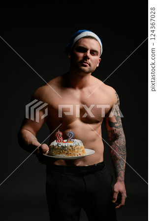 Man celebrating 32nd birthday with cake in festive atmosphere Man celebrating 32nd birthday with cake in festive atmosphere 124367028