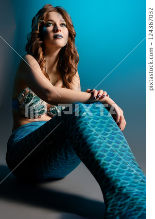 Woman poses elegantly in mermaid cosplay with intricate body art 124367032