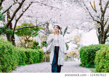 沿著櫻花樹散步的年輕女子 沿著櫻花樹散步的年輕女子 124367622