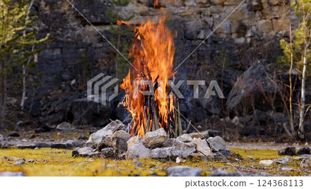 Beautiful Crackling Campfire in a Rocky Landscape , Sunrise , Authentic Place 124368113