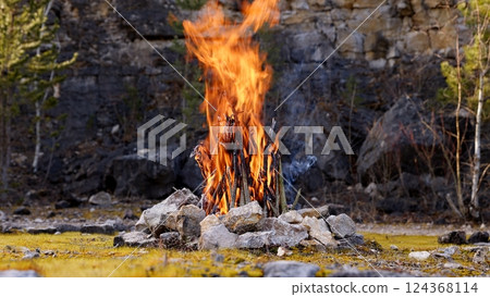 Beautiful Crackling Campfire in a Rocky Landscape , Sunrise , Authentic Place Beautiful Crackling Campfire in a Rocky Landscape , Sunrise , Authentic Place 124368114
