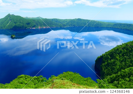 Lake Mashu reflecting the sky in early summer. Teshikaga, Hokkaido, Japan. Late June. Lake Mashu reflecting the sky in early summer. Teshikaga, Hokkaido, Japan. Late June. 124368146